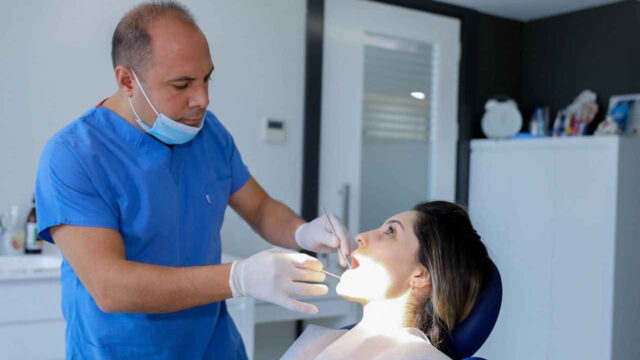 Antalya Diş Hekimleri Odası Başkanı Dr. Dt. Gassan Yücel, modern klinik ortamında bir hastaya periodontoloji tedavisi uyguluyor.